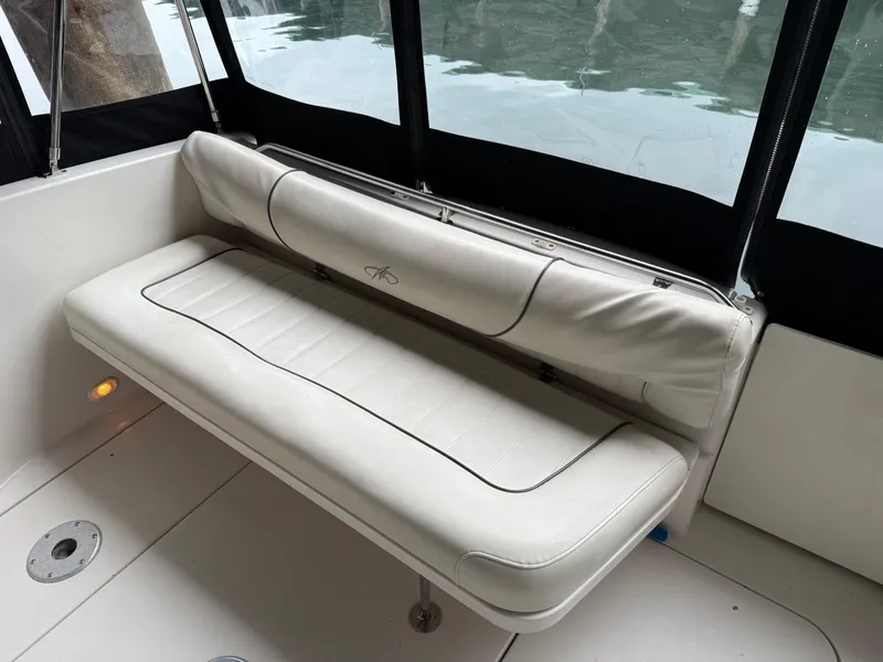 Slide: The Image of 2003 Monterey 302 Cruiser interior with white cushioned seating by the water. - 11