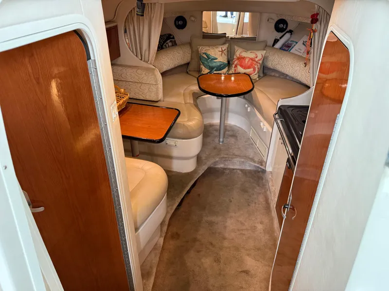 Slide: The Image of 2003 Monterey 302 Cruiser cabin interior with seating, table, and kitchen area. - 19