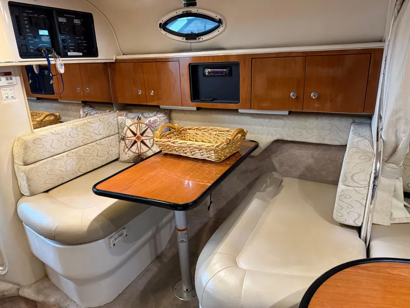 Slide: The Image of 2003 Monterey 302 Cruiser interior with dining area, wooden cabinets, and cushioned seating. - 23