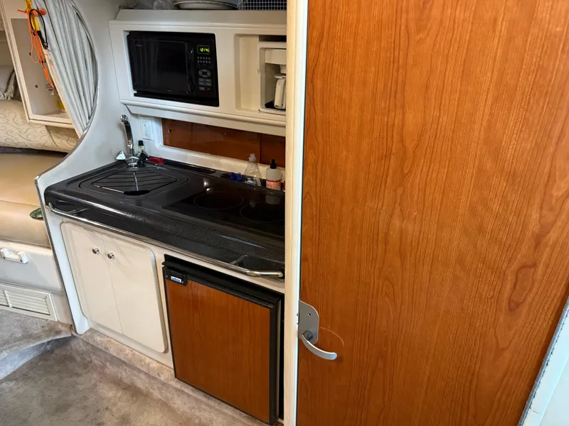 Slide: The Image of 2003 Monterey 302 Cruiser interior kitchen with microwave, sink, and mini fridge. - 26