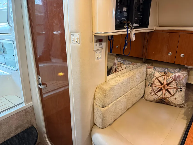 Slide: The Image of Interior of a 2003 Monterey 302 Cruiser with cushioned seating and nautical-themed pillows. - 36