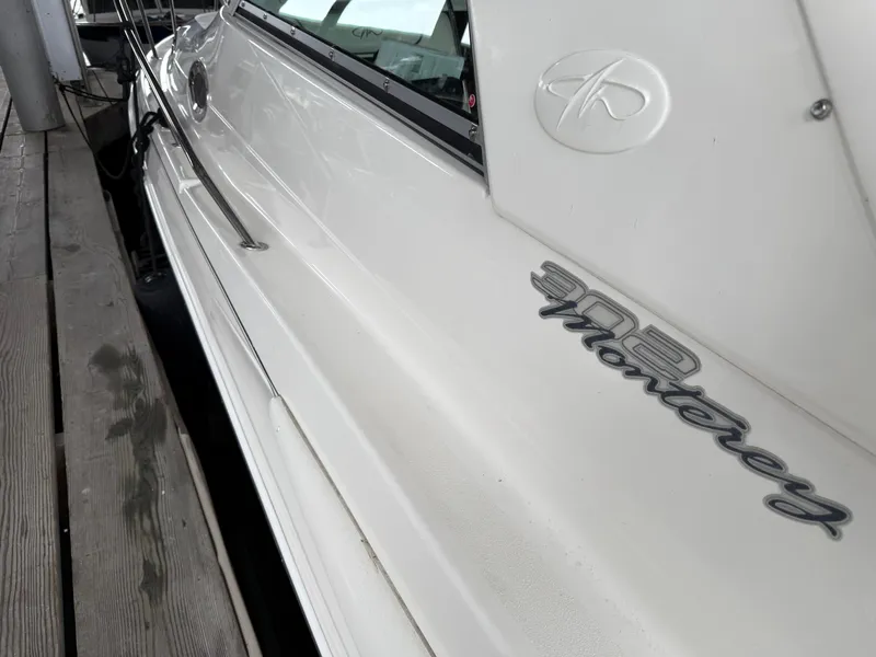 Slide: The Image of 2003 Monterey 302 Cruiser docked, showcasing sleek white exterior and logo. - 45