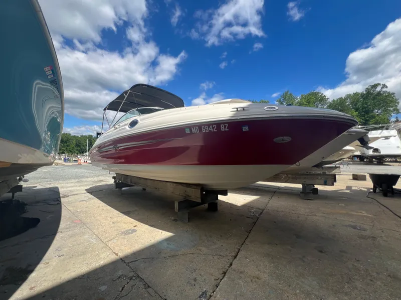 Slide: The Image of 2009 Sea Ray 240 Sundeck boat on dry dock under a clear blue sky. - 0