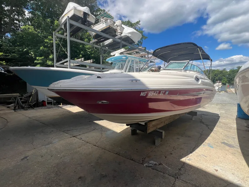 Slide: The Image of 2009 Sea Ray 240 Sundeck boat on display under a clear blue sky. - 1
