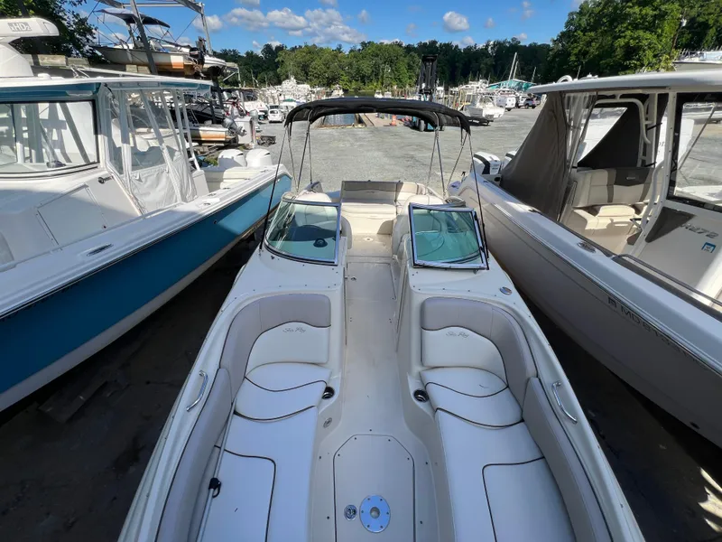 Slide: The Image of 2009 Sea Ray 240 Sundeck boat docked between two other boats. - 3