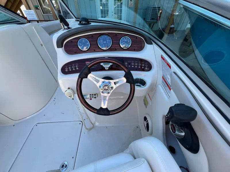 Slide: The Image of 2009 Sea Ray 240 Sundeck boat dashboard with steering wheel and gauges. - 5