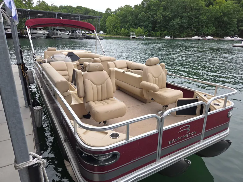 Slide: The Image of 2009 Bennington 2577RFSi pontoon boat docked on a serene lake. - 0