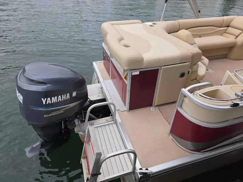Slide: The Image of 2009 Bennington 2577RFSi pontoon boat with Yamaha outboard motor on a calm lake. - 2