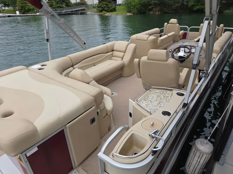 Slide: The Image of 2009 Bennington 2577RFSi pontoon boat with beige seating and helm, docked on a lake. - 4