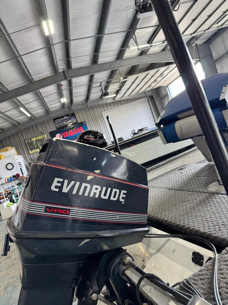 Slide: The Image of Evinrude outboard motor on Grumman 1676B boat, 1994 model, in a garage setting. - 13