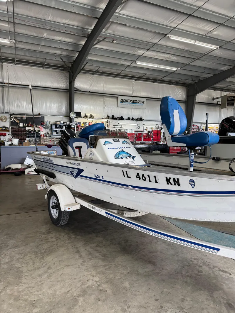 Slide: The Image of 1994 Grumman 1676B boat on trailer in indoor showroom. - 3