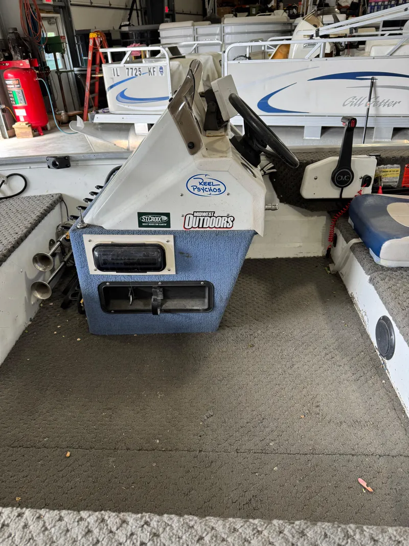 Slide: The Image of 1994 Grumman 1676B boat interior with steering console and seating. - 8