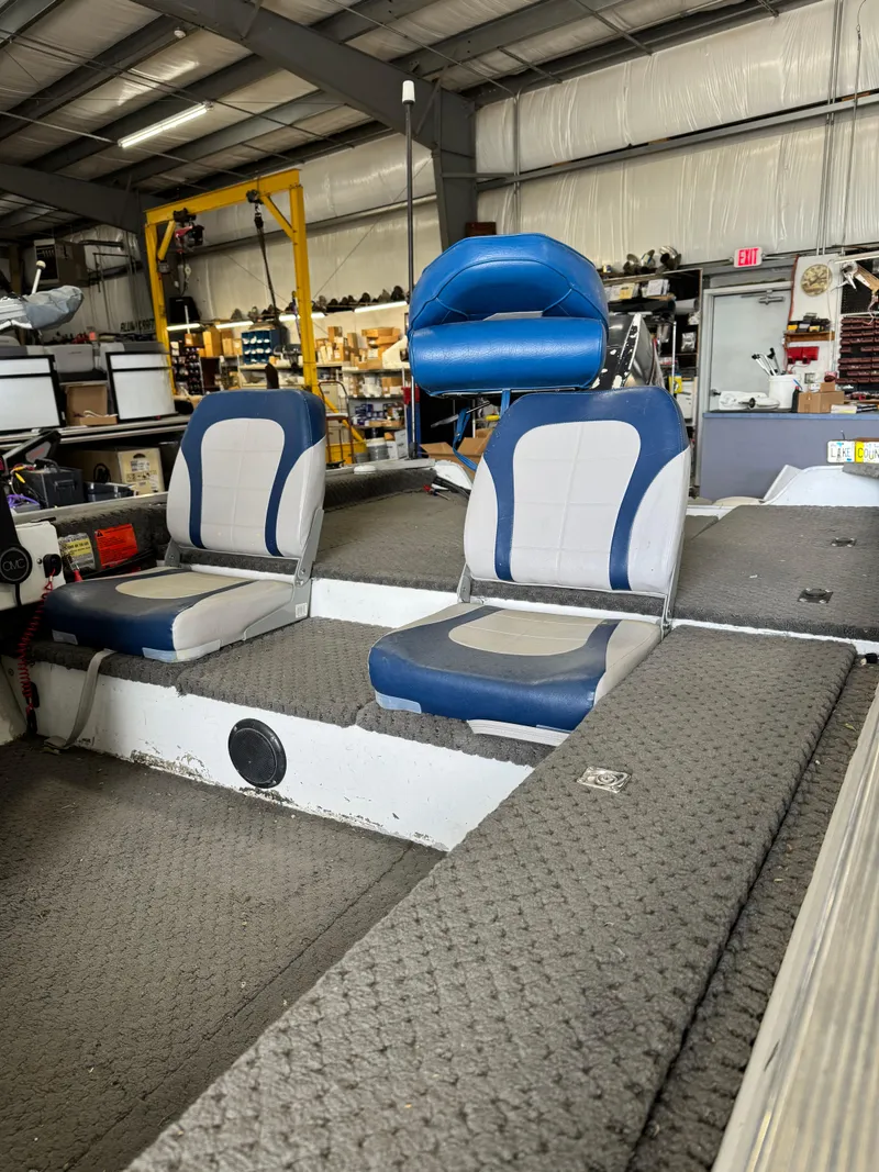 Slide: The Image of 1994 Grumman 1676B boat interior with blue and white seats in a workshop setting. - 9