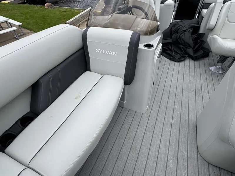 Slide: The Image of 2024 Sylvan Mirage 822 LZ boat interior with gray seating and flooring. - 13