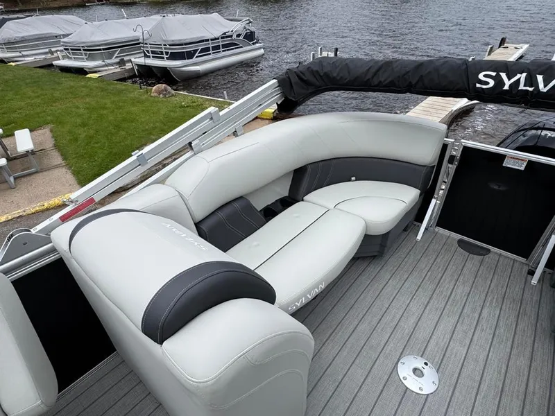 Slide: The Image of 2024 Sylvan Mirage 822 LZ pontoon boat with sleek seating and docked at a lakeside. - 15