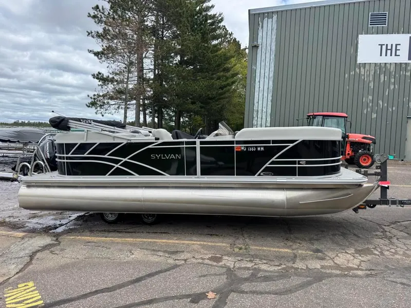 Slide: The Image of 2024 Sylvan Mirage 822 LZ pontoon boat parked outdoors near a building. - 3