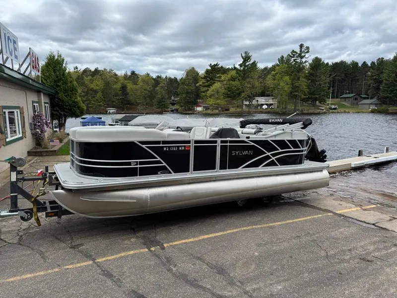 Slide: The Image of 2024 Sylvan Mirage 822 LZ pontoon boat on trailer by a lakeside dock. - 4