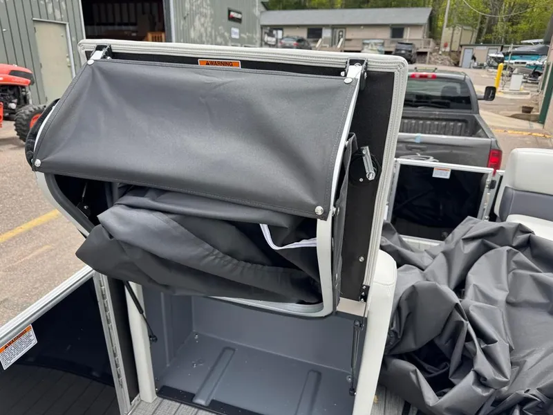 Slide: The Image of 2024 Sylvan Mirage 822 LZ boat storage compartment with cover partially open. - 9
