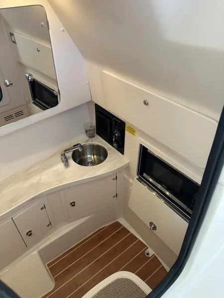 Slide: The Image of 2024 Grady-White Freedom 335 boat interior with sink and storage cabinets. - 11