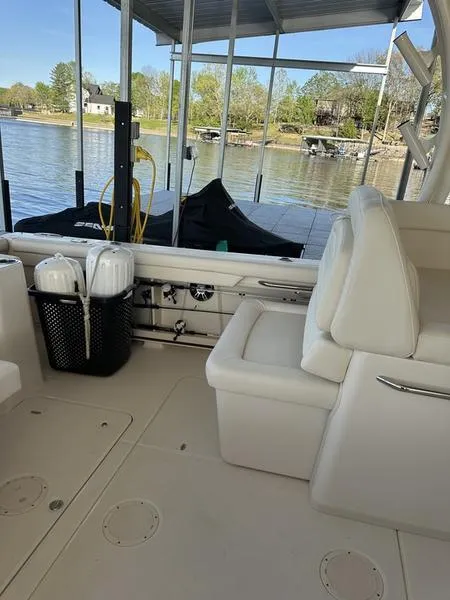 Slide: The Image of 2024 Grady-White Freedom 335 boat interior with seating, docked by a serene lake. - 17