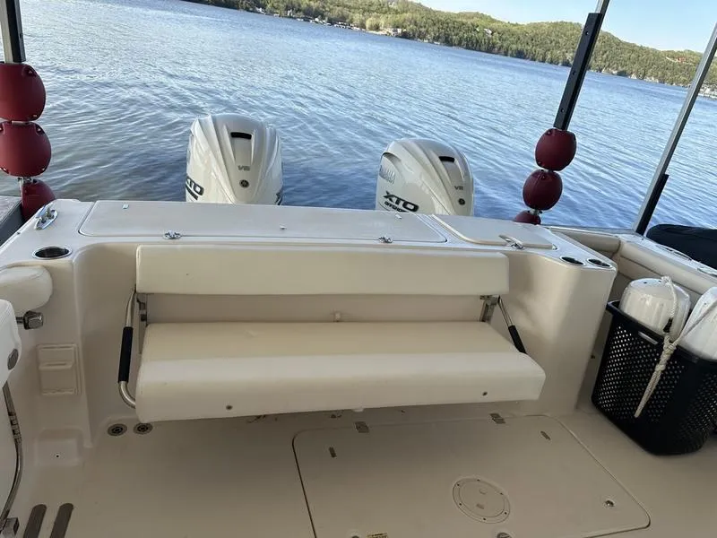 Slide: The Image of 2024 Grady-White Freedom 335 boat with dual outboard engines on a serene lake. - 18