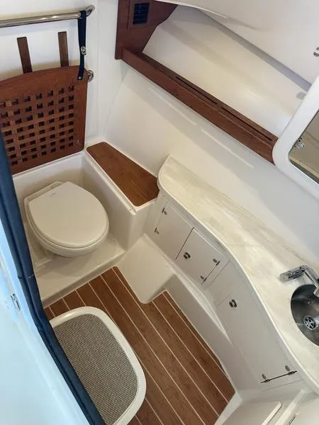 Slide: The Image of 2024 Grady-White Freedom 335 boat bathroom with wood accents and modern fixtures. - 6