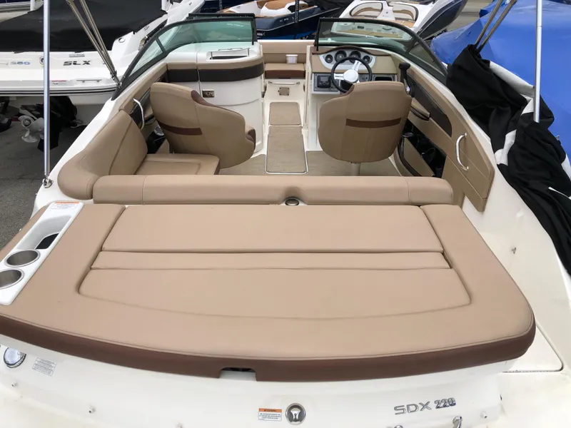 Slide: The Image of 2017 Sea Ray SDX 220 boat interior with beige seating and dashboard. - 3