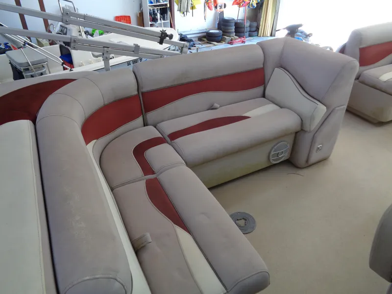 Slide: The Image of 2015 Sweetwater 2086 boat interior with beige and red cushioned seating. - 12