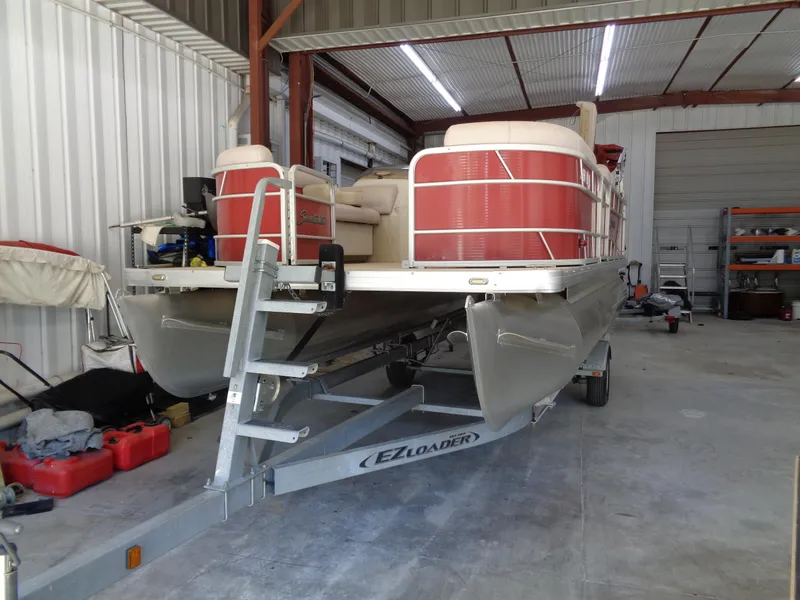 Slide: The Image of 2015 Sweetwater 2086 pontoon boat on EZ Loader trailer in a storage facility. - 6