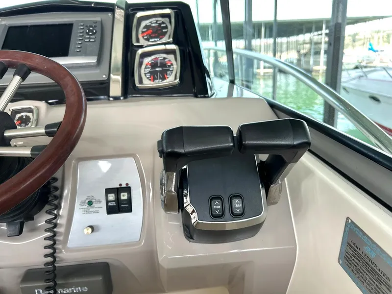 Slide: The Image of Control panel of a 2009 Chaparral 350 Signature boat, featuring steering wheel and throttle controls. - 43