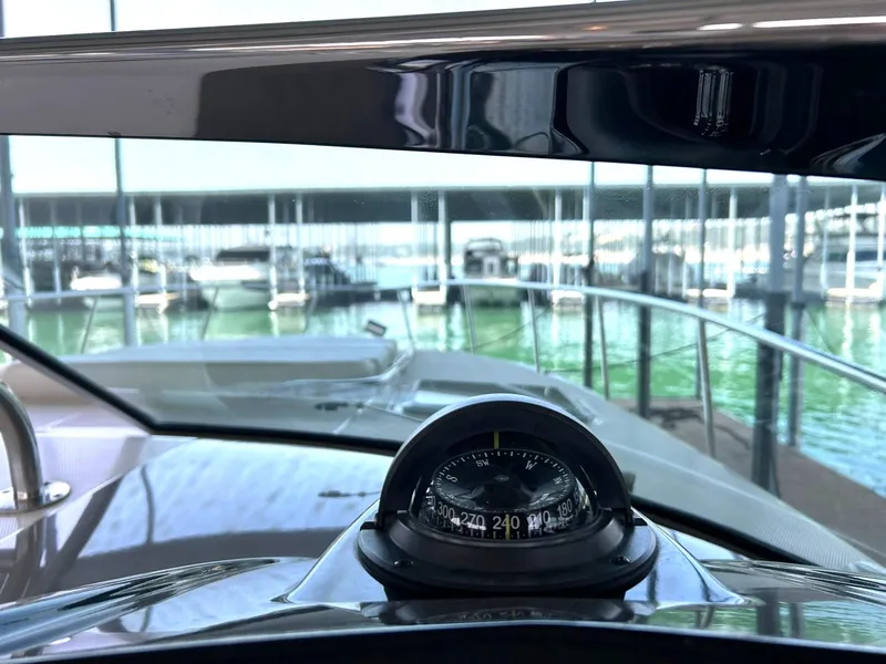 Slide: The Image of 2009 Chaparral 350 Signature boat dashboard with compass, docked at marina. - 46