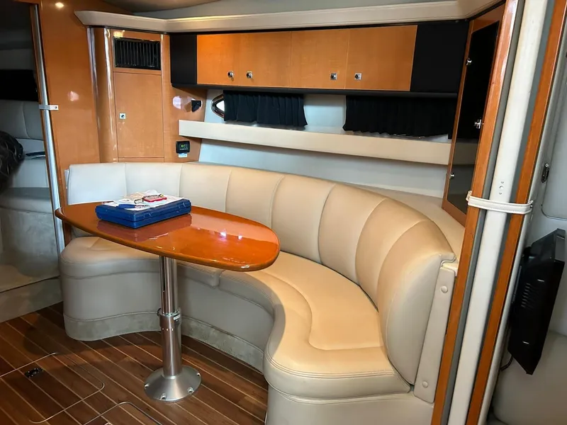 Slide: The Image of 2009 Chaparral 350 Signature yacht interior with curved seating and wooden table. - 5