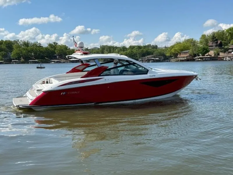 The Image of 2022 Cobalt A36BR boat on a calm lake under a clear blue sky. - 0