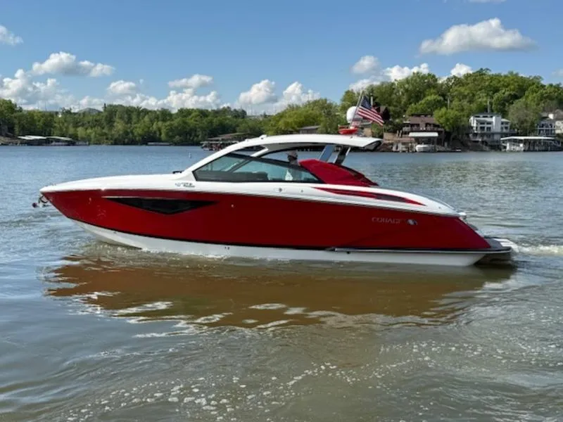Slide: The Image of 2022 Cobalt A36BR boat on a lake, red and white design, clear sky, scenic background. - 12