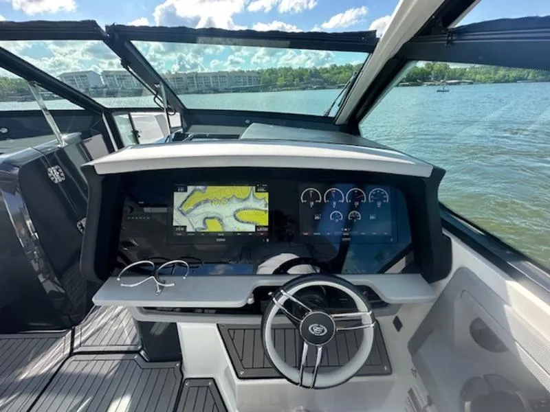 Slide: The Image of 2022 Cobalt A36BR boat dashboard with navigation screens and steering wheel on a sunny day. - 15