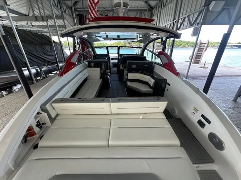 Slide: The Image of 2022 Cobalt A36BR boat interior with white seating, docked under a covered area. - 16