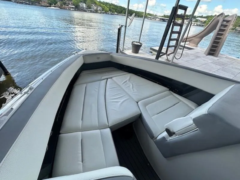 Slide: The Image of 2022 Cobalt A36BR boat with spacious seating, docked by a serene lake. - 24