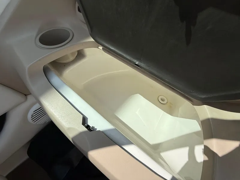Slide: The Image of Open storage compartment in 2000 Chaparral 196 SSi boat, featuring cup holder and speaker. - 13