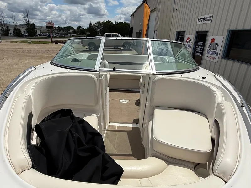 Slide: The Image of 2000 Chaparral 196 SSi boat interior with white seating and windshield, parked outdoors. - 3