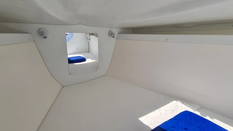 Slide: The Image of Interior cabin of a 2005 Marlago FS35 boat with white walls and blue cushions. - 12