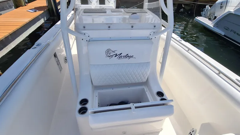Slide: The Image of 2005 Marlago FS35 boat interior with storage compartment and logo, docked by the water. - 15