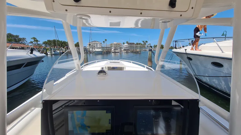 Slide: The Image of 2005 Marlago FS35 boat dashboard view, navigating through a marina with clear blue skies. - 17