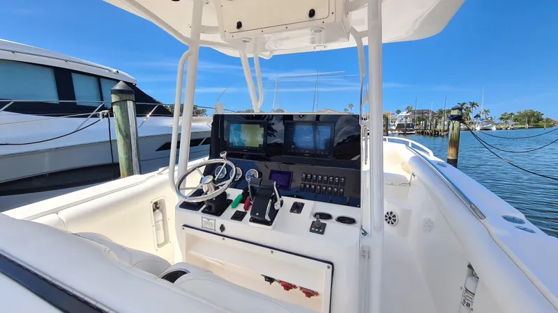 Slide: The Image of 2005 Marlago FS35 boat cockpit with steering wheel and navigation screens at marina. - 20