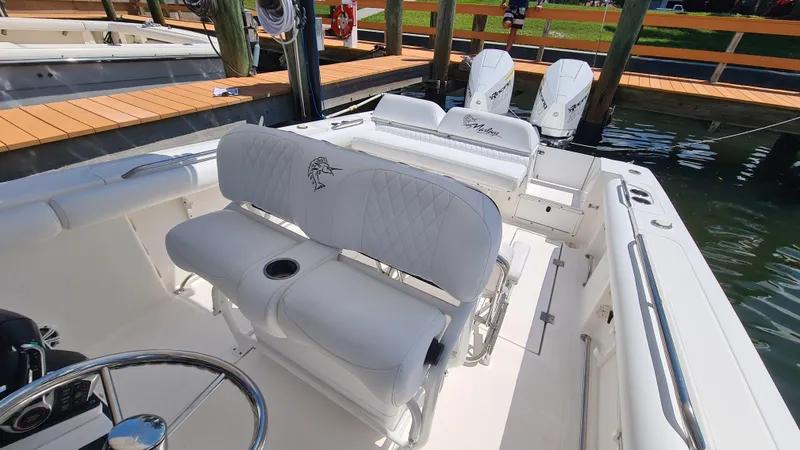 Slide: The Image of 2005 Marlago FS35 boat interior with white seating and dual outboard motors. - 21