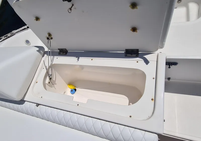 Slide: The Image of Open storage compartment on a 2005 Marlago FS35 boat, featuring quilted seating. - 24