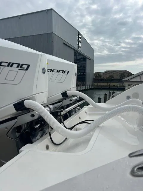 Slide: The Image of 2005 Marlago FS35 boat engines with hoses, docked near industrial building under cloudy sky. - 25