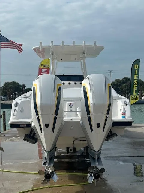 Slide: The Image of 2005 Marlago FS35 boat with dual outboard engines at a dock, American flag in background. - 26