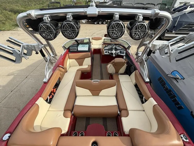 Slide: The Image of 2016 MasterCraft X23 boat interior with beige and brown seating, advanced sound system, and sleek design. - 17