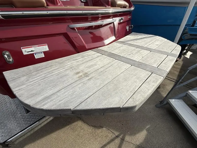 Slide: The Image of 2016 MasterCraft X23 boat with extended swim platform, red hull, and wooden deck. - 18