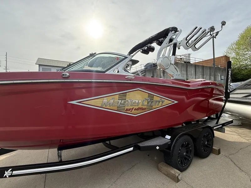 Slide: The Image of 2016 MasterCraft X23 surf edition boat on trailer, red exterior, side view. - 2